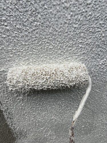 掛川市A様邸で砂骨ローラーによる外壁の模様付けを行う様子