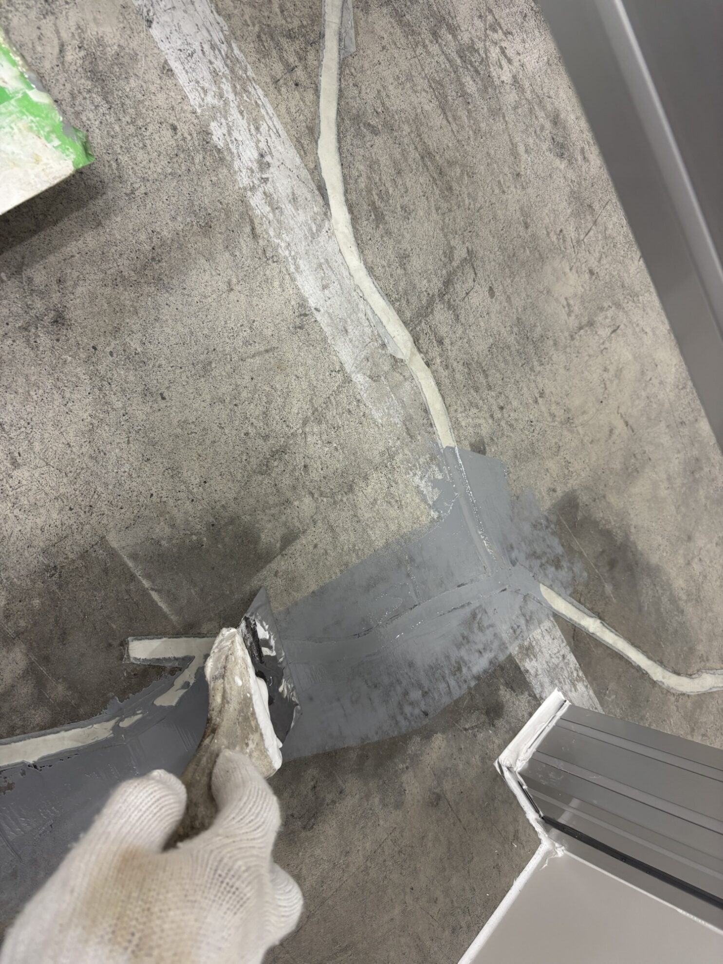 床のクラック補修をパテ処理で施工中の様子