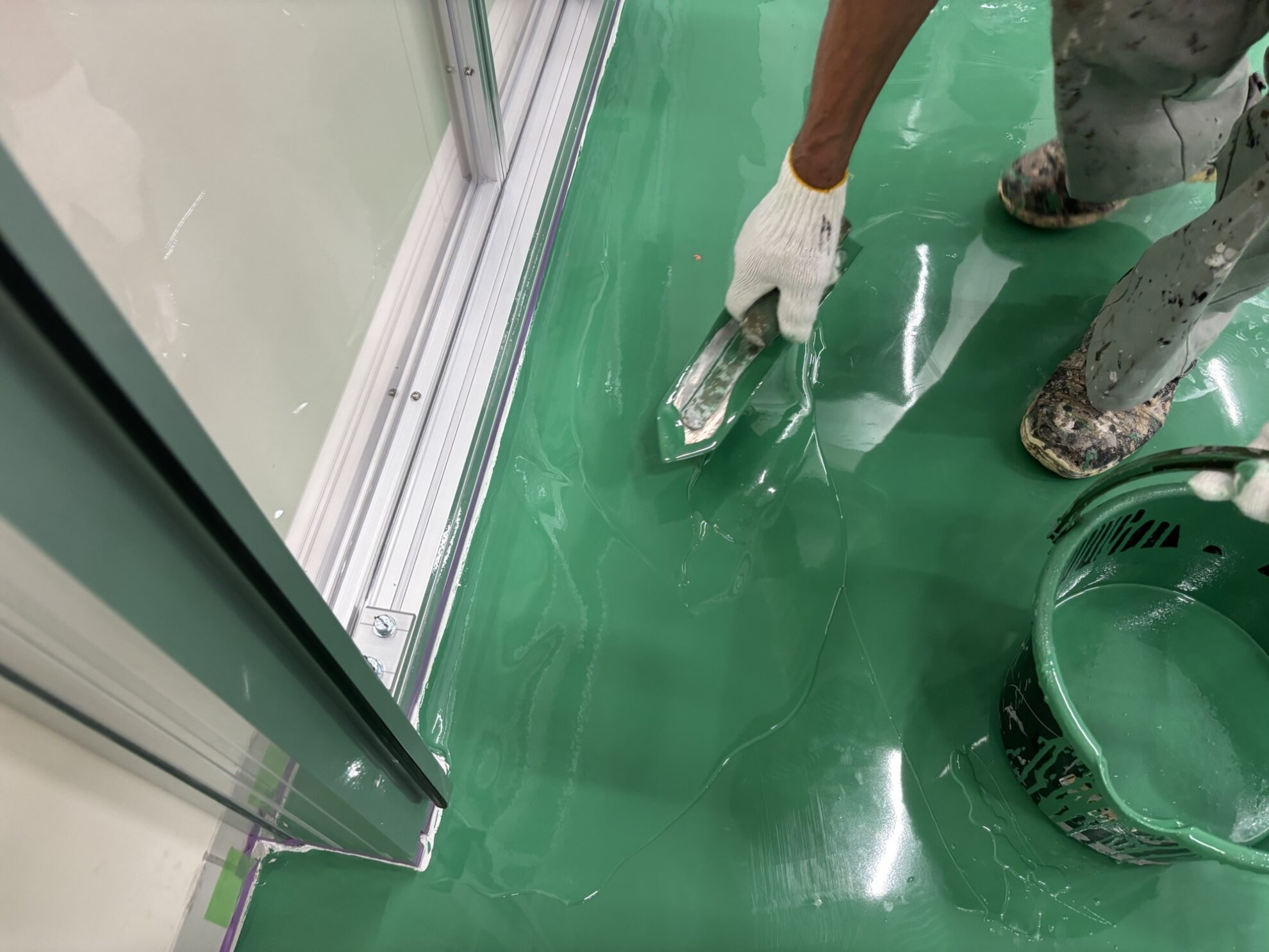 床塗装 上塗り施工中 ローラーで仕上げている様子